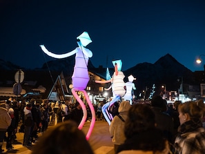 Un evento nocturno al aire libre con figuras iluminadas y una multitud de personas.