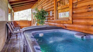 A wooden cabin with a hot tub, wooden deck, and a large window. - Convenient Pet friendly Pigeon Forge 2 Bedroom Internet-Hot Tub-Blackberry Ridge (Pigeon Forge)