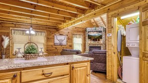 L’intérieur d’un chalet en bois comprend une cuisine, un coin repas et un salon.