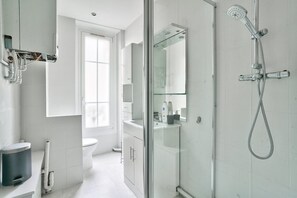 Chuveiro, toalhas de banho, papel higiênico 