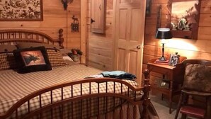 A wooden cabin bedroom with a bed, dresser, and a chair. - Mt. Cabin near water falls, skiing, shopping
Peaceful creek location




 (Maggie Valley)