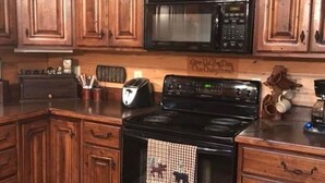 A kitchen with wooden cabinets, a microwave, a stove, and a toaster. - Mt. Cabin near water falls, skiing, shopping
Peaceful creek location




 (Maggie Valley)