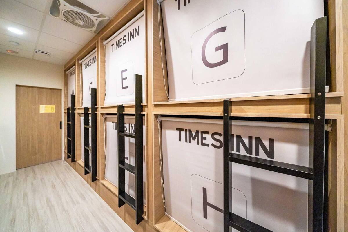 A hallway with multiple rooms labeled TIMES INN, each with a distinct letter on the wall.