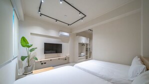 A modern hotel room with two beds, a flat-screen TV, built-in shelving, and a potted plant. - Times Inn - Tainan  (Tainan)