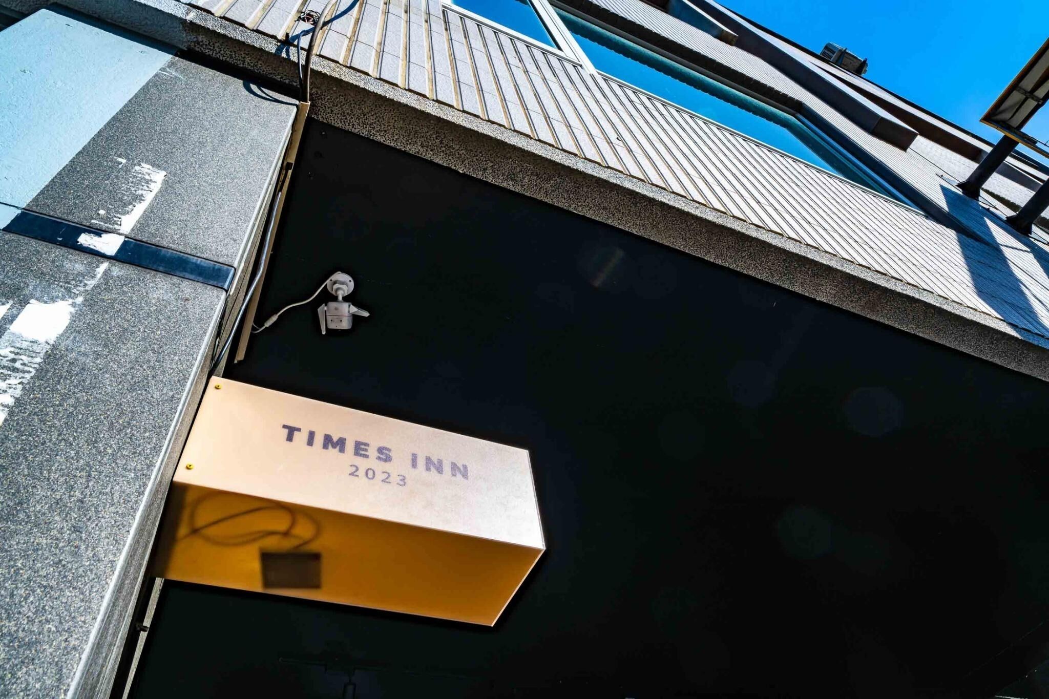 Letrero de Times Inn 2023 en la fachada de un edificio.