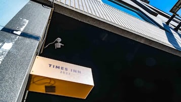 Letrero de Times Inn 2023 en la fachada de un edificio.