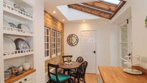 A dining area with a wooden table, chairs, and a clock on the wall.