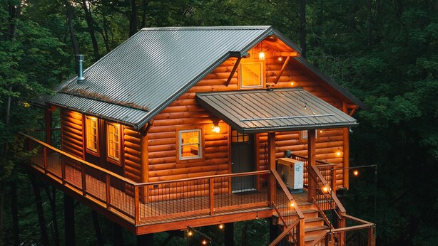 Een houten chalet met balkon en trap.