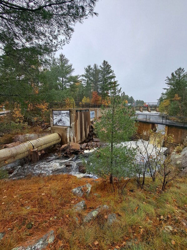 A river flowing through a forested area with a bridge and a dam structure. - Home Away From Home, come and relax in a beautiful old country home with Jacuzzi (South River)