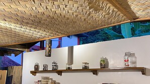 Une cuisine moderne avec un plafond en osier, des étagères en bois et divers appareils de cuisine.