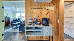 Interior de madeira com balcão de café, ar condicionado e ventilador de teto.