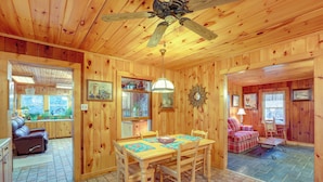 A wooden interior with a dining table, chairs, a ceiling fan, and a fireplace. - Dog-friendly Burnsville Home w/ Patio & Trails! (Burnsville)