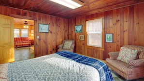 A wooden-paneled room with a bed, two sofas, and a chair. - Dog-friendly Burnsville Home w/ Patio & Trails! (Burnsville)