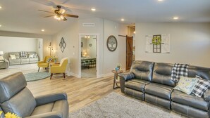 A spacious living room with a leather sofa, a dining area, and a ceiling fan. - Modern Bloomington Home ~ 10 Mi to Bear Lake! (Bloomington)