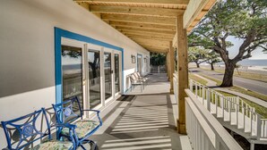 A covered outdoor area with a wooden ceiling, a row of chairs, and a view of the beach. - Front Row Beachfront Long Beach Getaway (Long Beach)