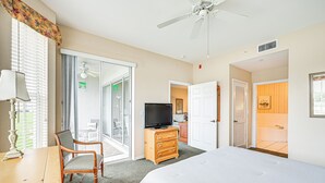 A hotel room with a bed, a television, a dresser, a chair, and a desk. - Naples Condo w/ Pond Views & Patio - Near Golf! (Naples)