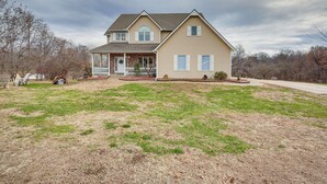 A two-story house with a front porch, a garage, and a well-maintained lawn. - 5 Mi to Fort Osage: Countryside Studio (Sibley)