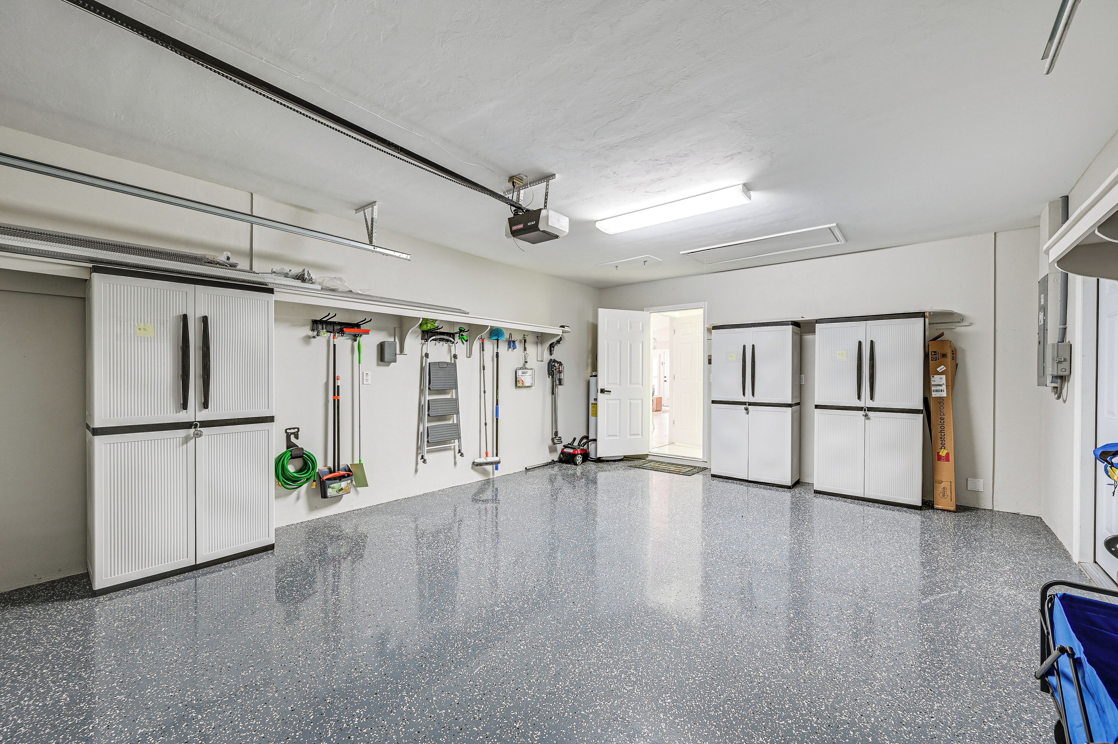 A spacious, well-lit room with white cabinets, a projector, and a large mirror.