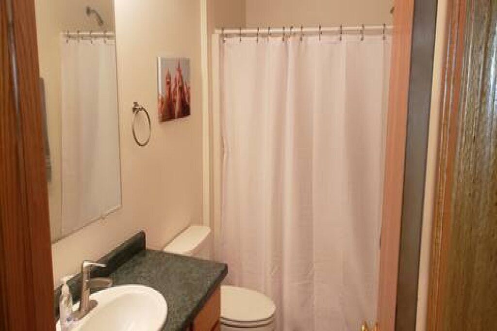Un baño con lavamanos, inodoro y cortina de ducha.