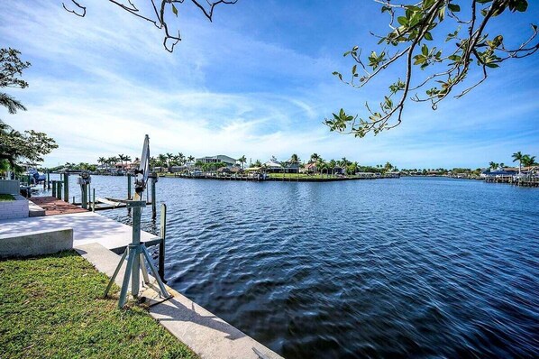 A waterfront view with a dock, a camera on a tripod, and a clear sky.