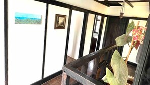 Ein Flur mit Holzwandverkleidung, einem gerahmten Bild an der Wand und einer Pendelleuchte.