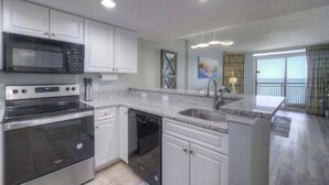 A modern kitchen with white cabinets, stainless steel appliances, and a granite countertop. - HS-1129 Spacious 2-bedroom condo in Myrtle Beach (Myrtle Beach)