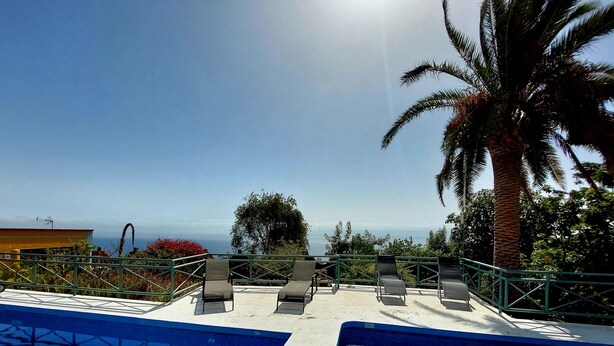 Una piscina con lettini e vista sull'oceano.