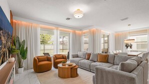 A modern living room with a sofa set, a coffee table, and a dining area with a table and chairs.