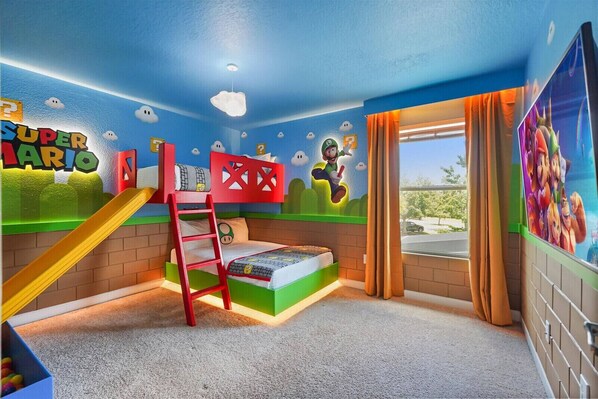 A children's playroom with a bunk bed, a slide, and Mario-themed decorations.
