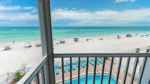 Une vue sur la piscine, avec une plage et l’océan en arrière-plan.