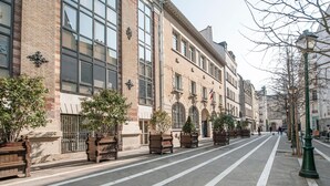 A street lined with historic buildings, featuring large windows and traditional architecture. - MARAIS LOVELY BEAUBOURG A (Paris)