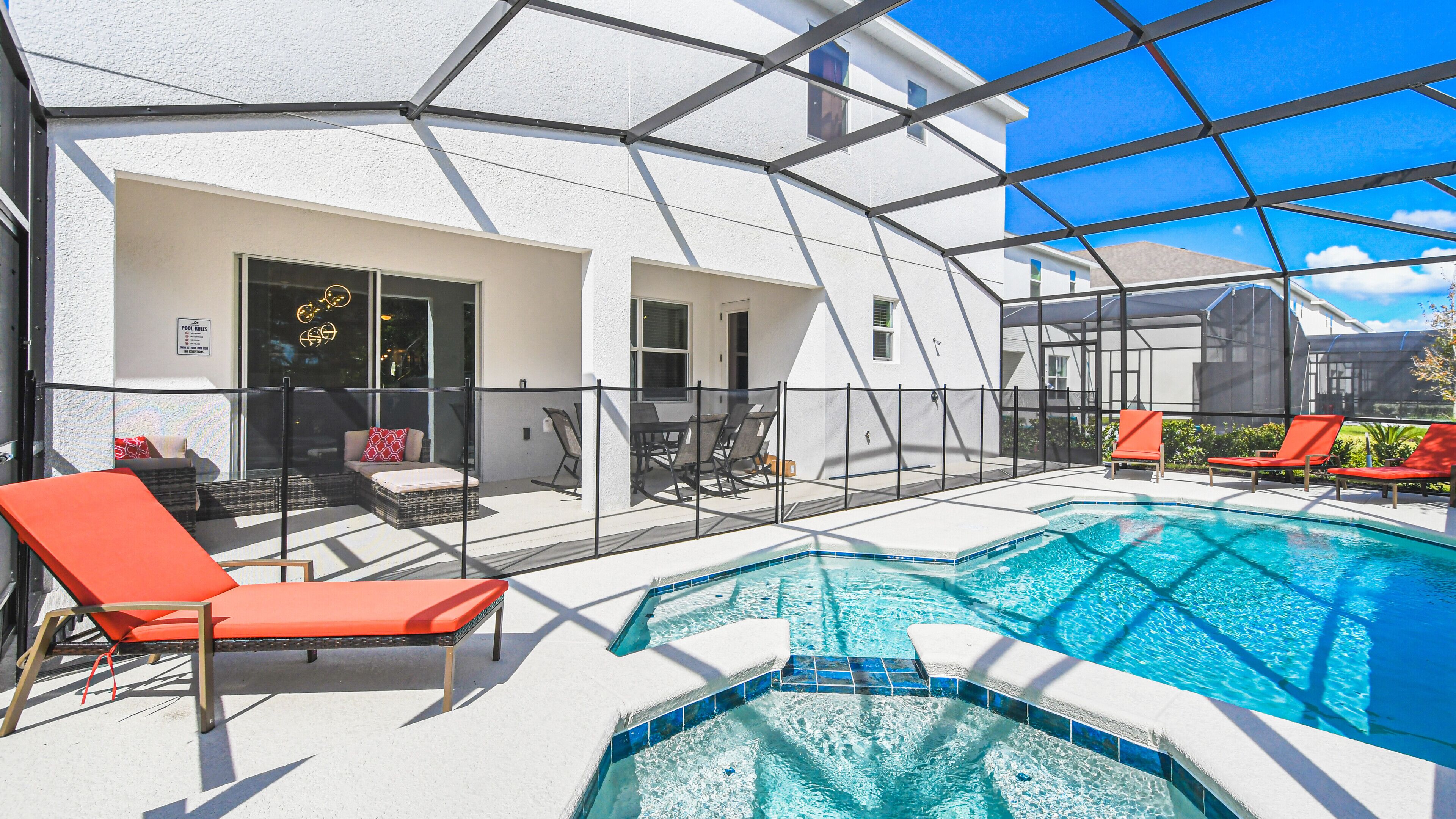 A pool area with lounge chairs, a covered seating area, and a clear view of the pool.