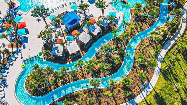 An aerial view of a resort with a winding pool, sun loungers, and palm trees. - Last Minute Disney! Private Pool, Hot Tub & Themed Bedrooms. Book Now! #106587 (Orlando)