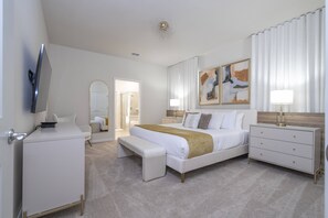 Relax in a spacious room with a large bed, bedside table, and mirror.