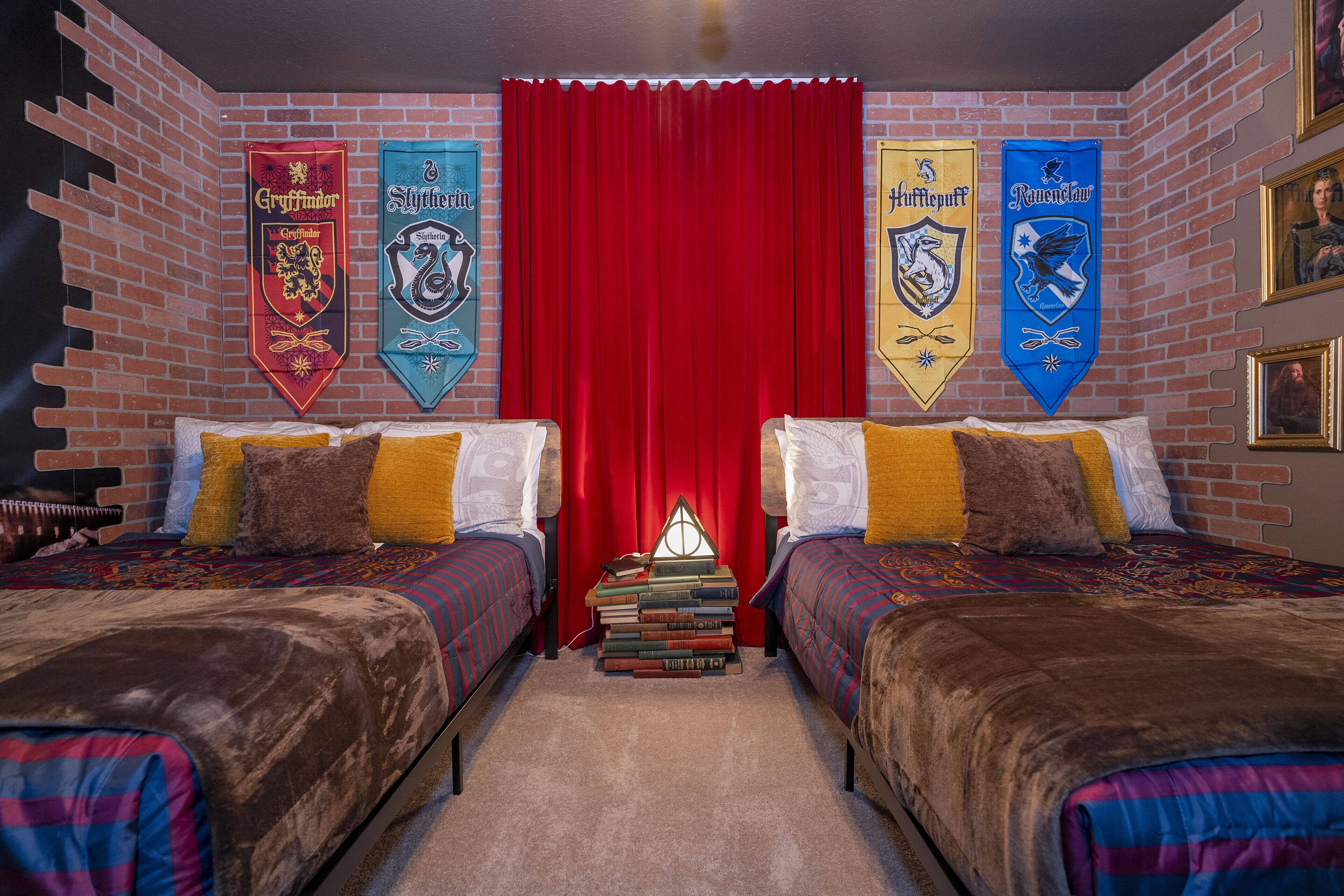 A room with two beds, a red curtain, and banners on the wall.