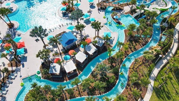 An aerial view of a resort with a winding pool, lounge areas, and palm trees. - Last Minute Disney! Private Pool, Hot Tub, Game Room & Themed Bedrooms. Book Now! #107907 (Orlando)