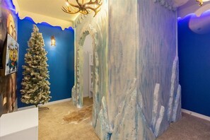 Una habitación con pared azul, un árbol de Navidad y una pared de hielo artificial.
