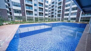 Un immeuble résidentiel moderne doté d’une piscine sur le toit.