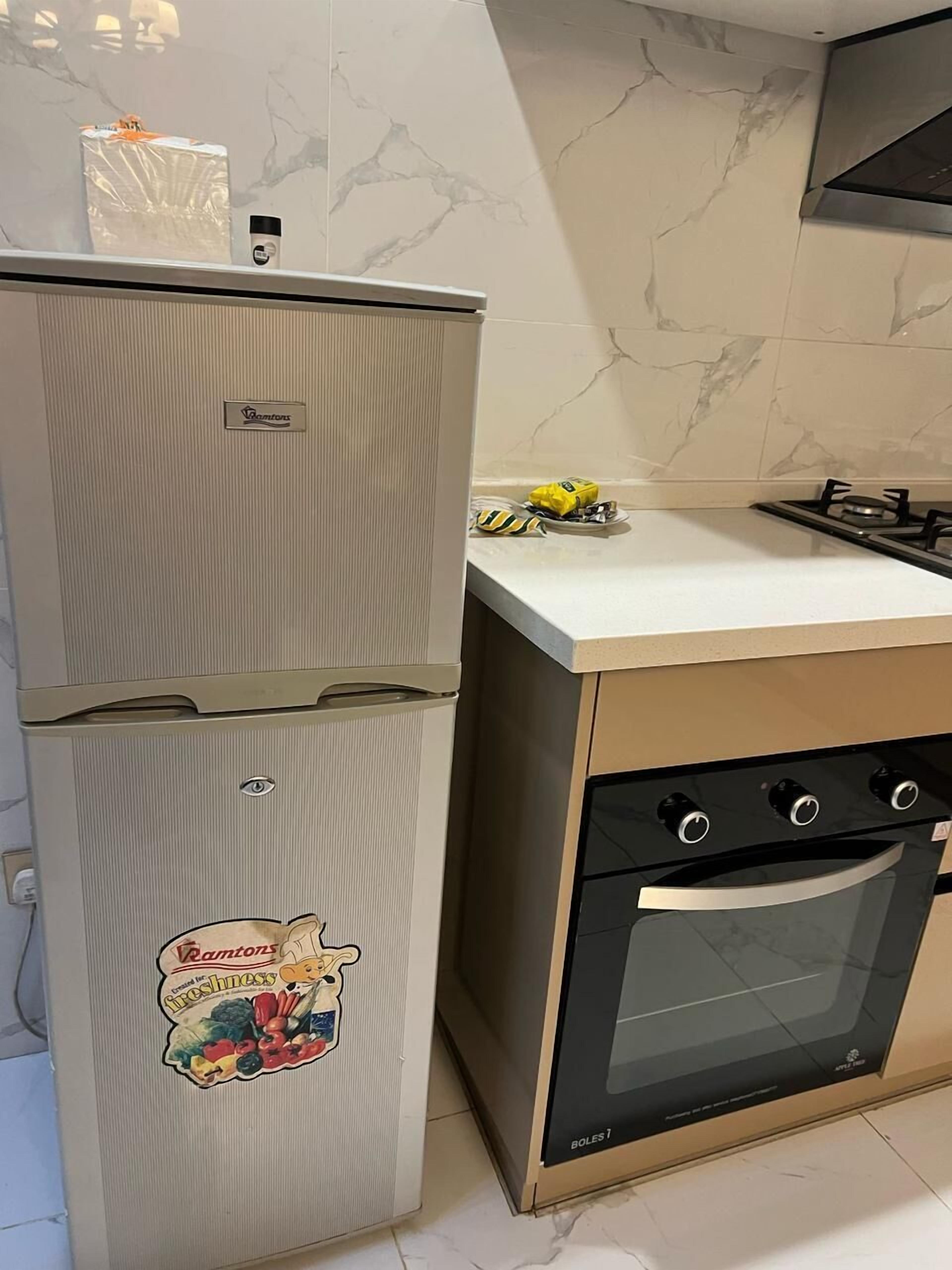 Una cucina compatta con frigorifero, fornello e forno.
