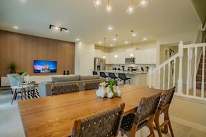 Una cocina moderna con armarios blancos, un refrigerador de acero inoxidable y un microondas.