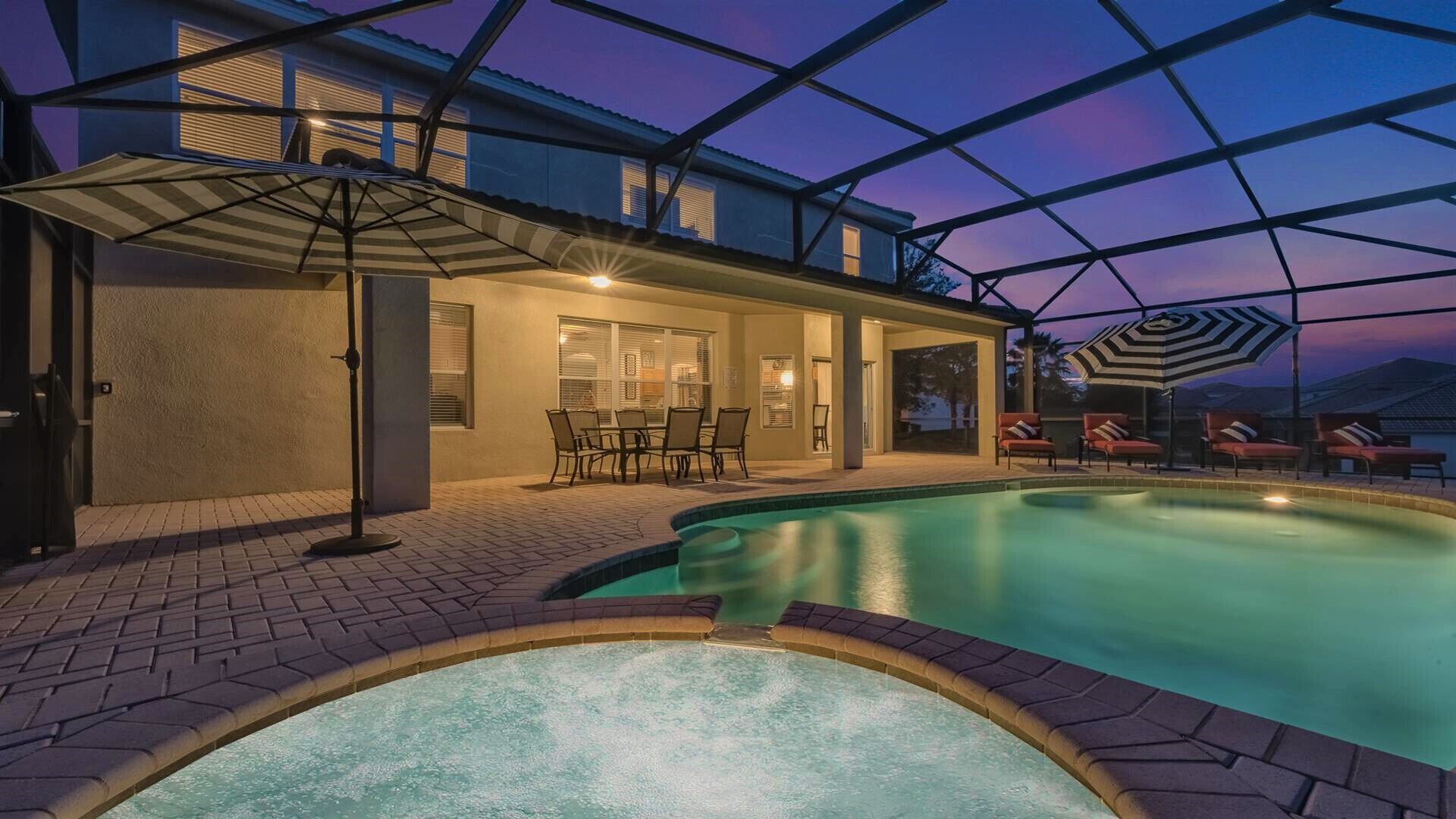 A swimming pool with a glass ceiling, outdoor seating, and a patio area.