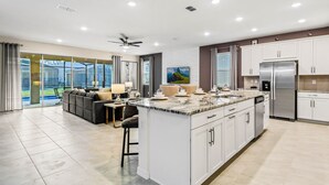 A modern kitchen with a large island, white cabinetry, and stainless steel appliances. - Last Minute Disney! Private Pool, Hot Tub & Themed Bedrooms. Book Now! #91755 (Orlando)