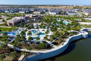 An aerial view of a resort with a central pool area, surrounded by palm trees and a curved walkway. - Last Minute Disney Getaway! Private Pool & Themed Bedrooms. Book Now! #98227 (Orlando)