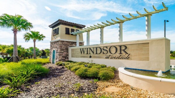 A sign for 'Windsor at Westside' with a pergola and a water feature. - Last Minute Disney Getaway! Villa with Private Pool & Hot Tub. Book Now! #100817 (Orlando)