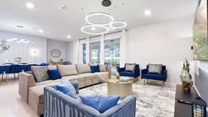 A modern living room with a sectional sofa, blue armchairs, and a coffee table.