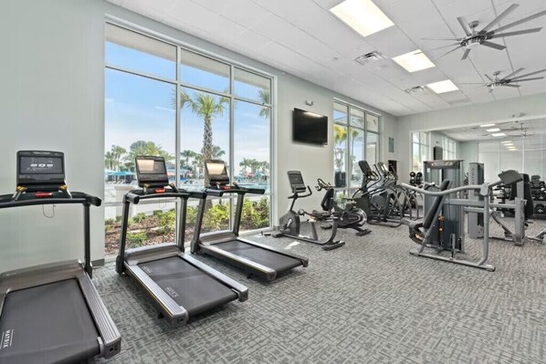 A gym with treadmills, elliptical machines, and weight equipment.