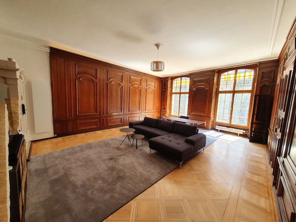 Une pièce spacieuse comprenant un grand meuble en bois, un canapé et une table à manger.