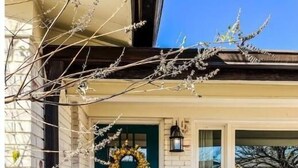 A two-story building with a green door, a wreath, and a small porch. - Myrtles on Madison House near ACU (Abilene)