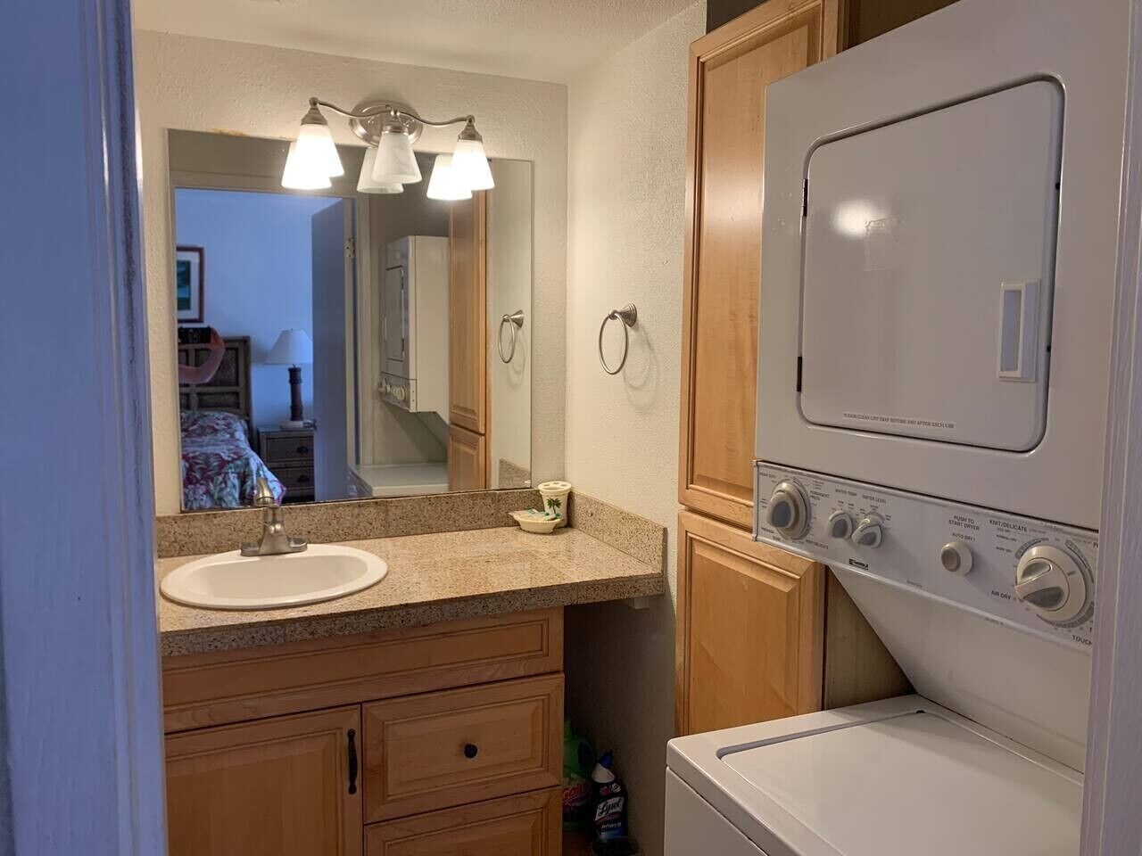 Une salle de bain équipée d’un lavabo, d’un miroir, d’un meuble-lavabo et d’un lave-linge.