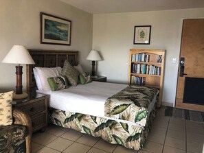 Una camera da letto con un letto, due comodini con lampade, una libreria e una porta.